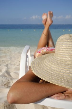 Woman sunbathing on a sun lounger on a tropical beach
